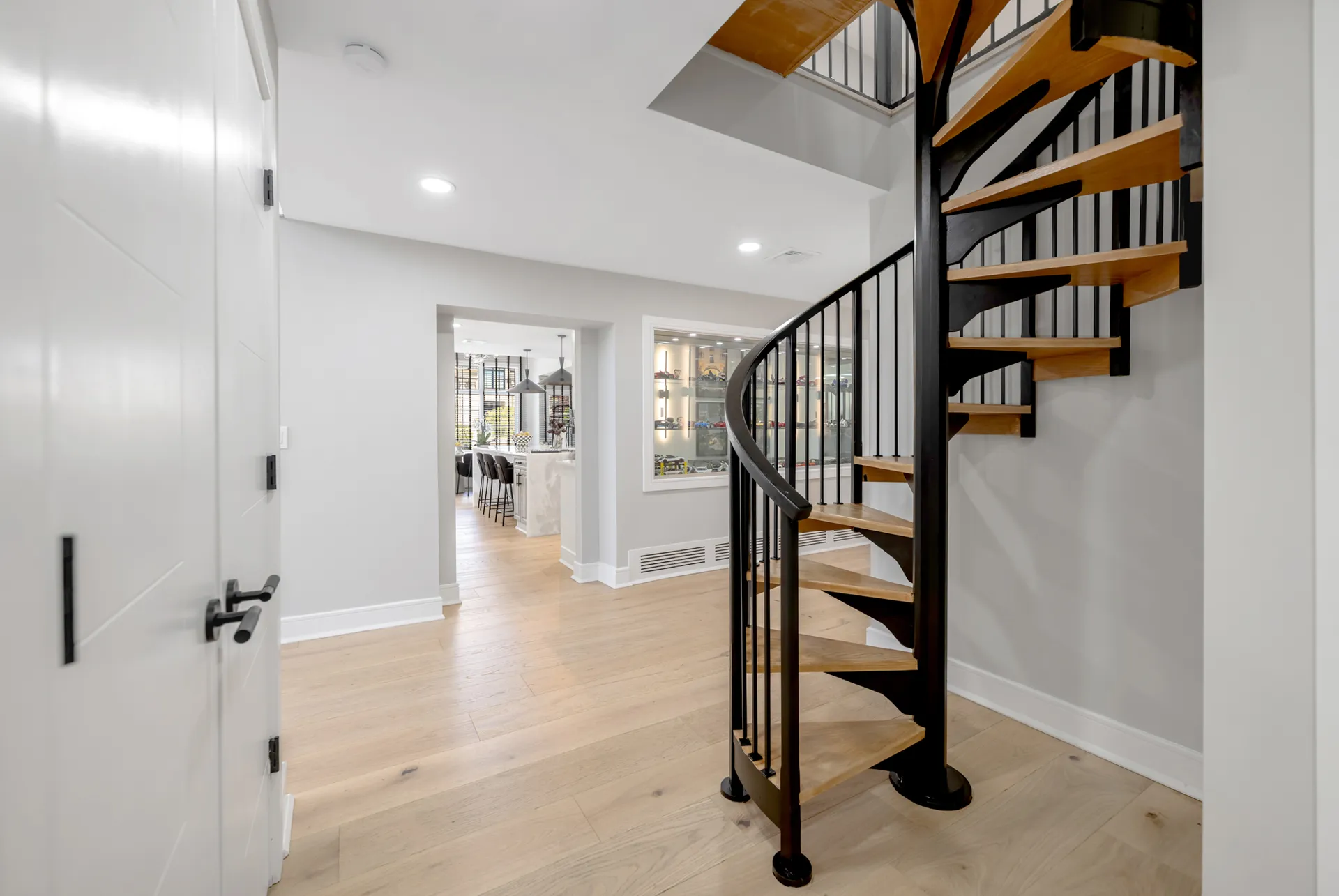 Redesigned spiral staircase after renovation — black steel with warm wood treads