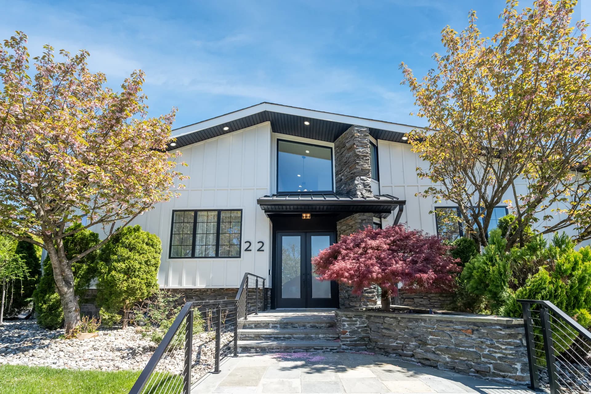 22 Berkshire Place front exterior after renovation — modern white facade with new stonework and landscaping