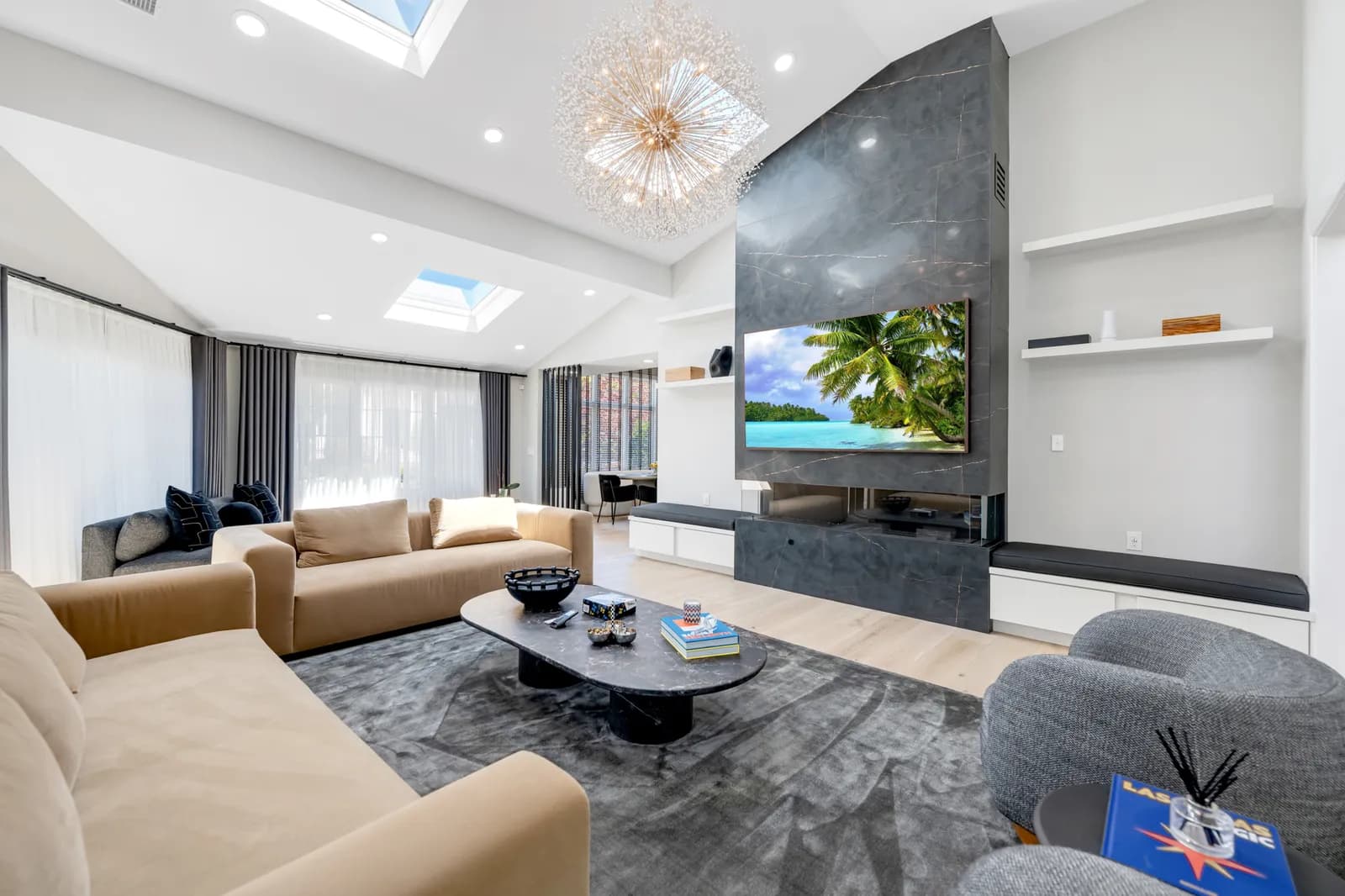 Living room after renovation — floor-to-ceiling stone fireplace with built-in media wall