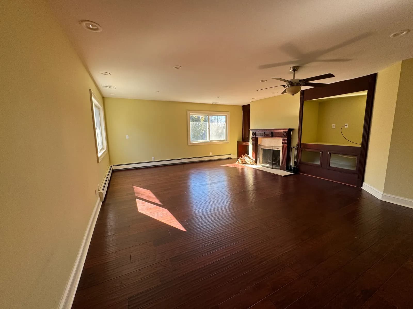 Living room before renovation — dated fireplace and worn flooring