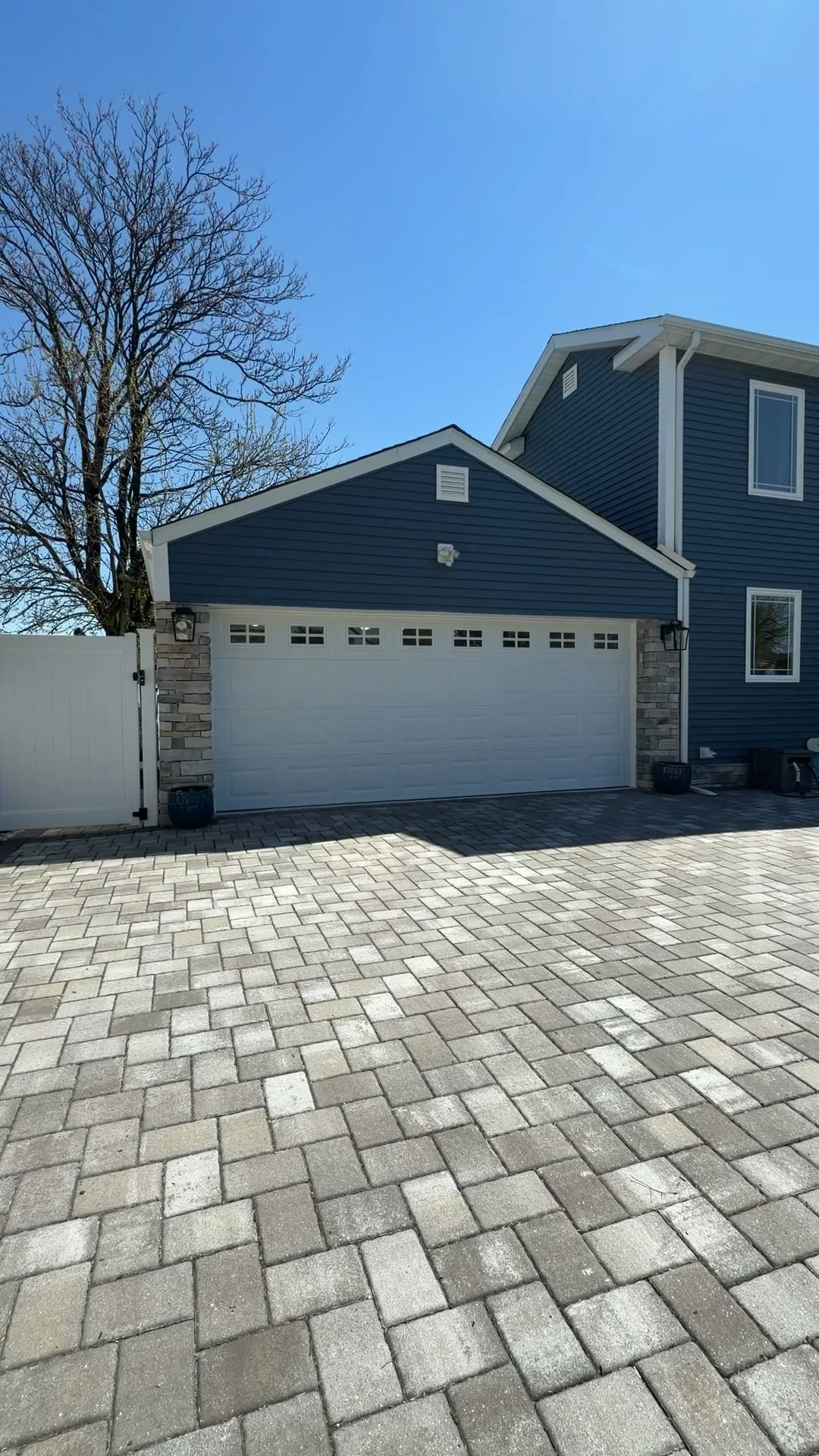 Custom garage — Elmwood Park, NJ — finished exterior with new carriage door, stone columns, and lanterns