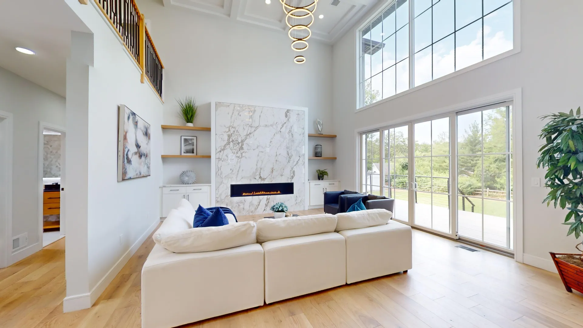 Finished great room — two-story windows and marble fireplace wall