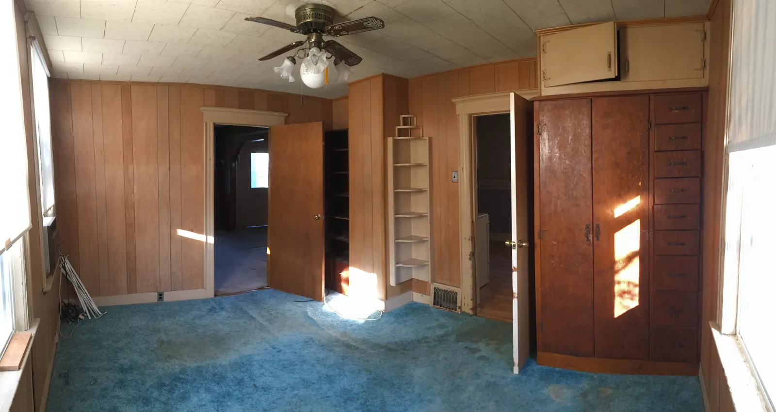 Dated wood-paneled room with worn carpet before renovation