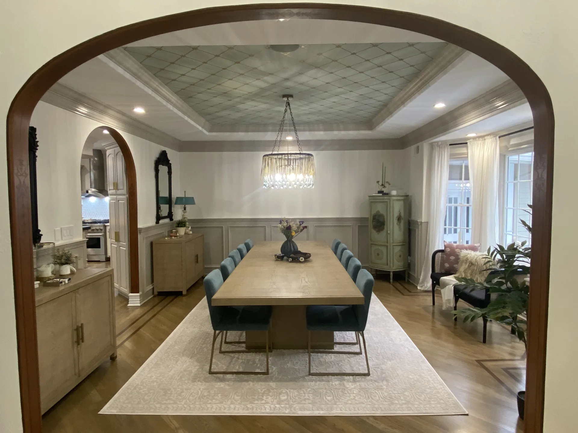 Formal dining room after renovation — lattice tray ceiling, crystal chandelier, and wainscoting