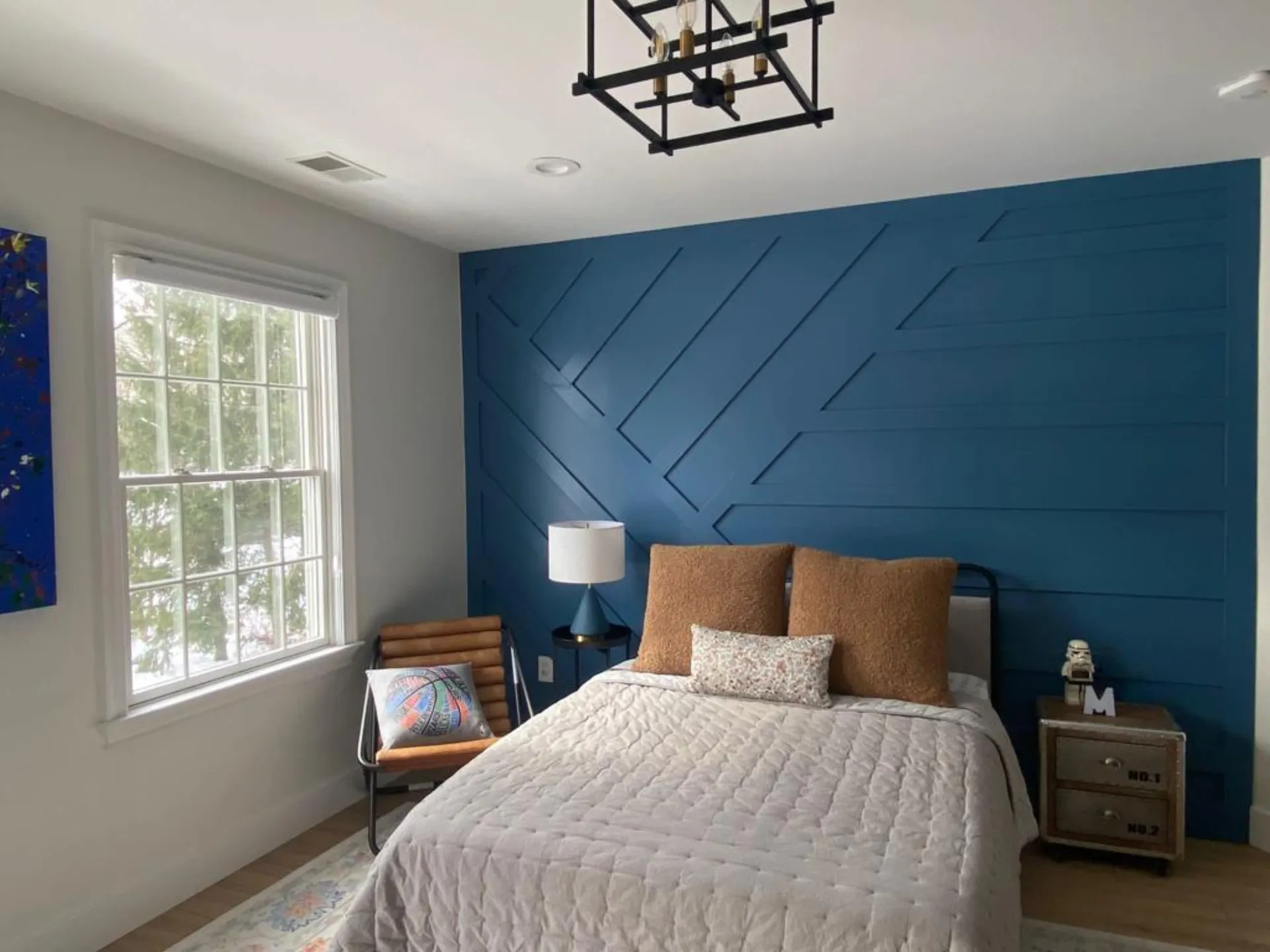 Bedroom after renovation — custom navy accent wall with diagonal millwork