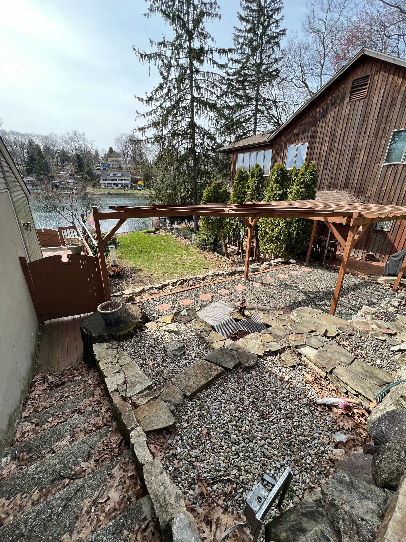 Overgrown backyard with debris and bare pergola before renovation